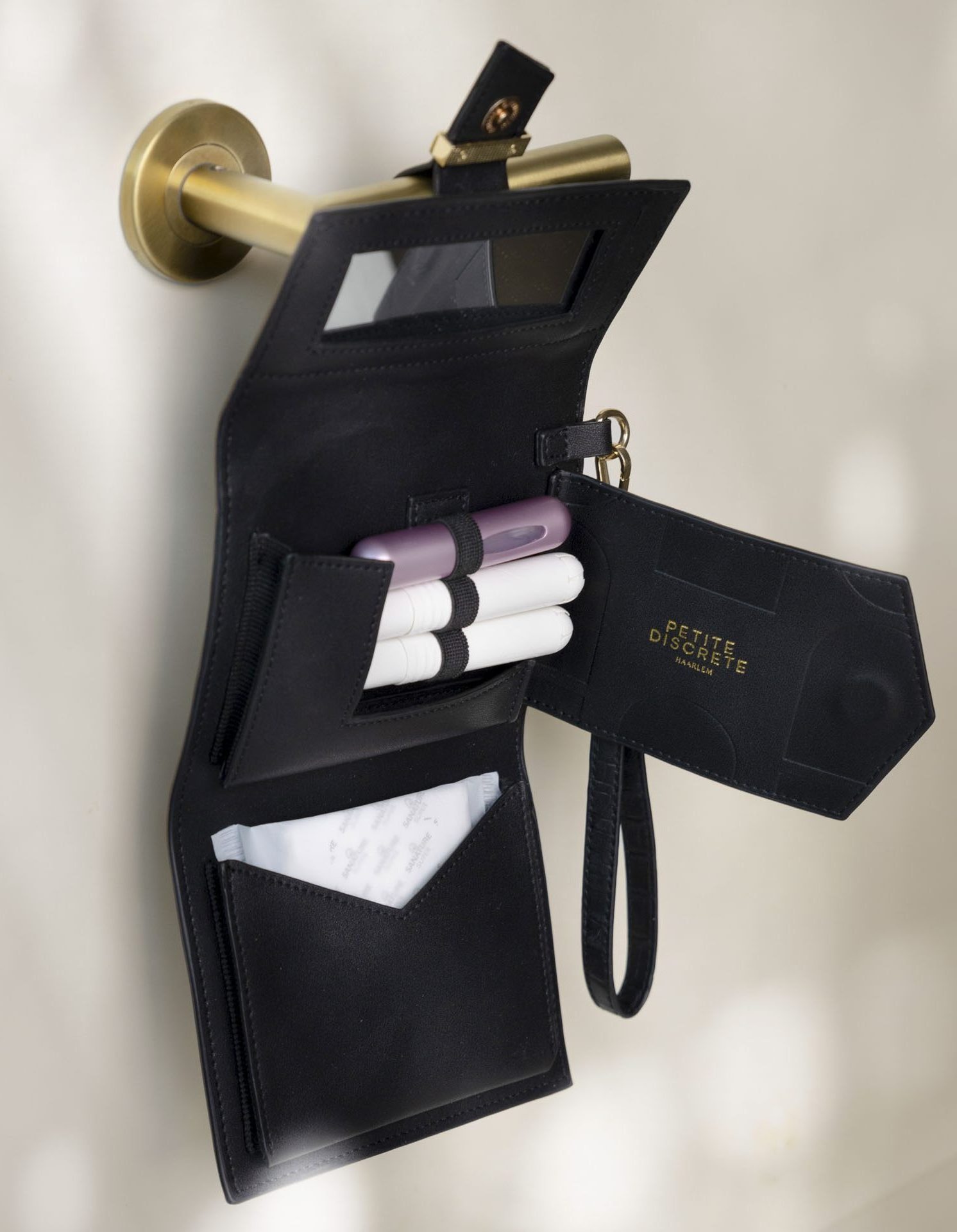 Tampons opbergtasje hangt aan een wc-deurklink. Met behulp van een antislip lus wordt de menstruatie tas om de deurklink geschoven